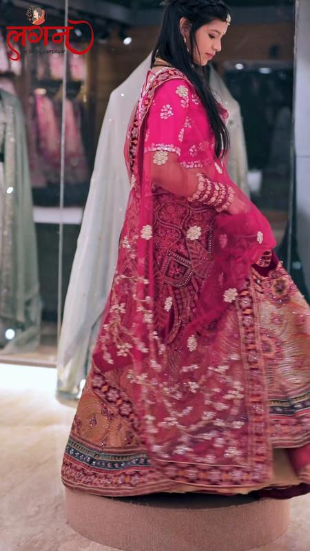 A pink bridal lehenga being tried on in the showroom