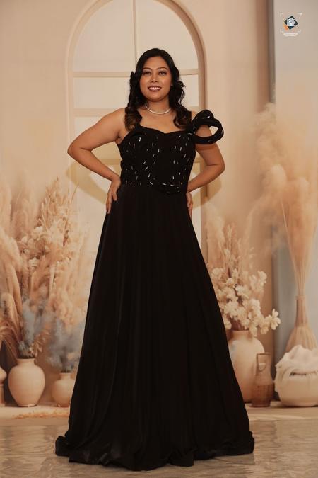 A black gown with a sculpted shoulder